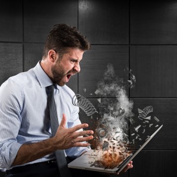 broken computer in a guys hands